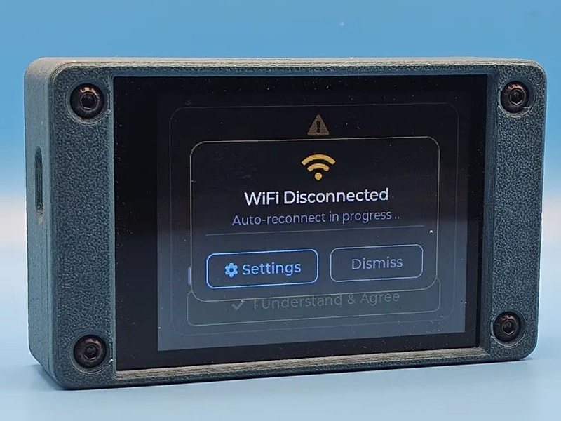 A CYGM in a grey printed case against a blue backdrop, showing a WiFi Disconnected notice with auto-reconnect in progress and Settings and Dismiss buttons.
